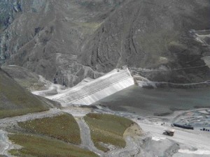 The 130-metre high dam. A 0.6 metre thick concrete plinth provides continuity between the grouted foundation and concrete face. A concrete curb system protects the steep upstream slope of filter.